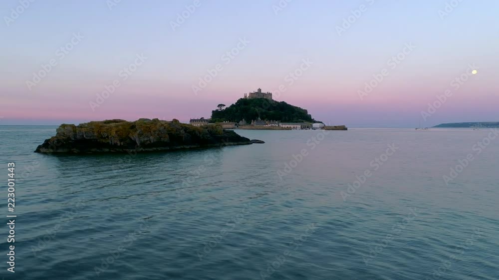 Drone slides behind rock with St Michaels Mount Cornwall at twilight Drone slides behind rock with St Michaels Mount Cornwall at twilight