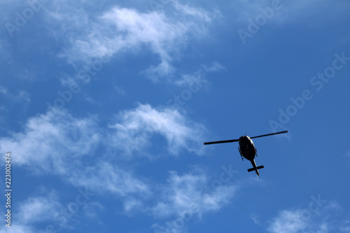 black helicopter aircraft during the flight with blue sky