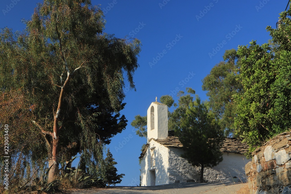 beautiful greek chapel  in white with traditional slate roof on Ikaria Island, Greece
