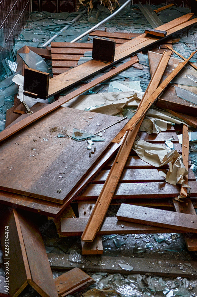 Obraz premium Shattered glass and pieces of wood on the floor in an abandoned building