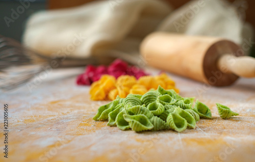 homemade fresh colored pasta on wooden background, cooking pasta in the kitchen, selective focus