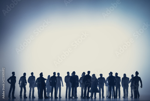 Group of people walking towards the white light.