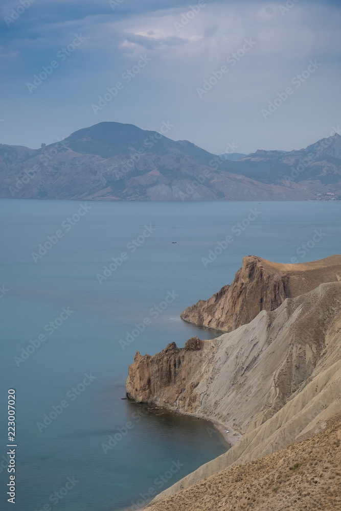 Cape Black sea in the village of Ordzhonikidze in the Crimea, in the summer with a textured sky with clouds and hilly terrain, landscape
