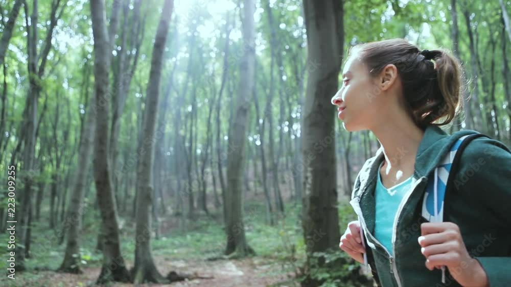 Portrait of Active healthy woman hiking in beautiful forest. Portrait of happy smiling young woman walking and seeing in forest during hike holidays. Portrait of Active healthy woman hiking in beautiful forest. Portrait of happy smiling young woman walking and seeing in forest during hike holidays.