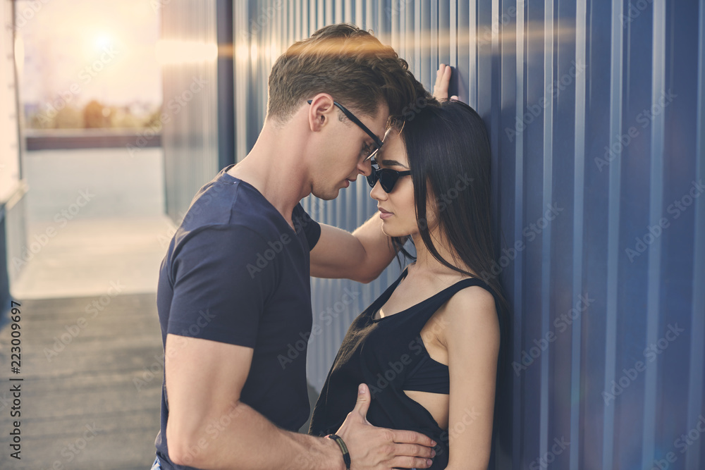 interracial sexy couple flirting and hugging on roof with backlit foto de  Stock | Adobe Stock