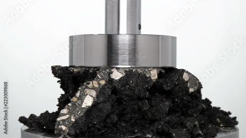 restoration of a piece of asphalt roadbed after destruction by hydraulic press, rewind, close-up