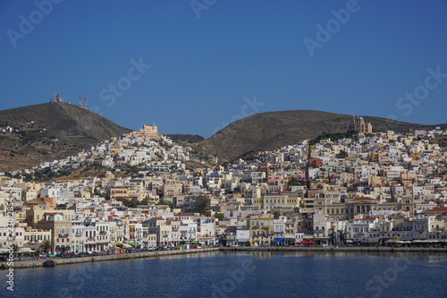 Syros, Greece: The hills, houses, churches, shops, and harbor of Ano Syros and Hermoupolis shine in the sun on the Aegean island of Syros.
