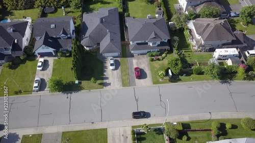 Aerial 4k Drone Following Shot of Red Car Pulling Out of Driveway in Canadian Suburbs with Cracks in Road