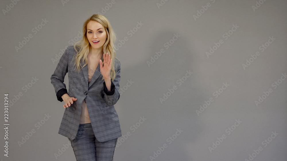 Happy dancer girl in suit dancing freestyle in office on the grey background. Happy dancer girl in suit dancing freestyle in office on the grey background.