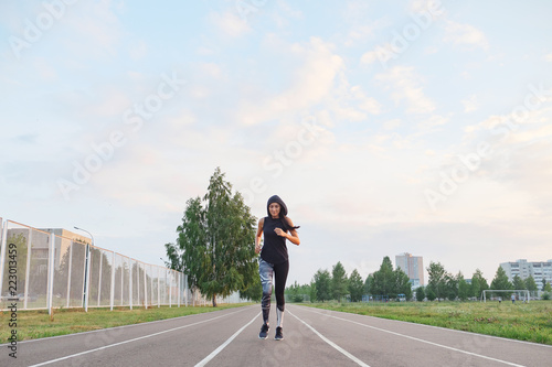 fit girl in hood running at the stadium outdoor