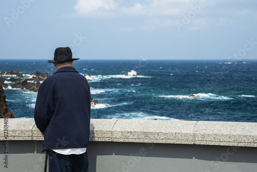 An elderly man on the oceanfront.