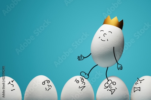 Concept of ambitiousness, careerism. An egg with golden crown walks through heads the white eggs. photo