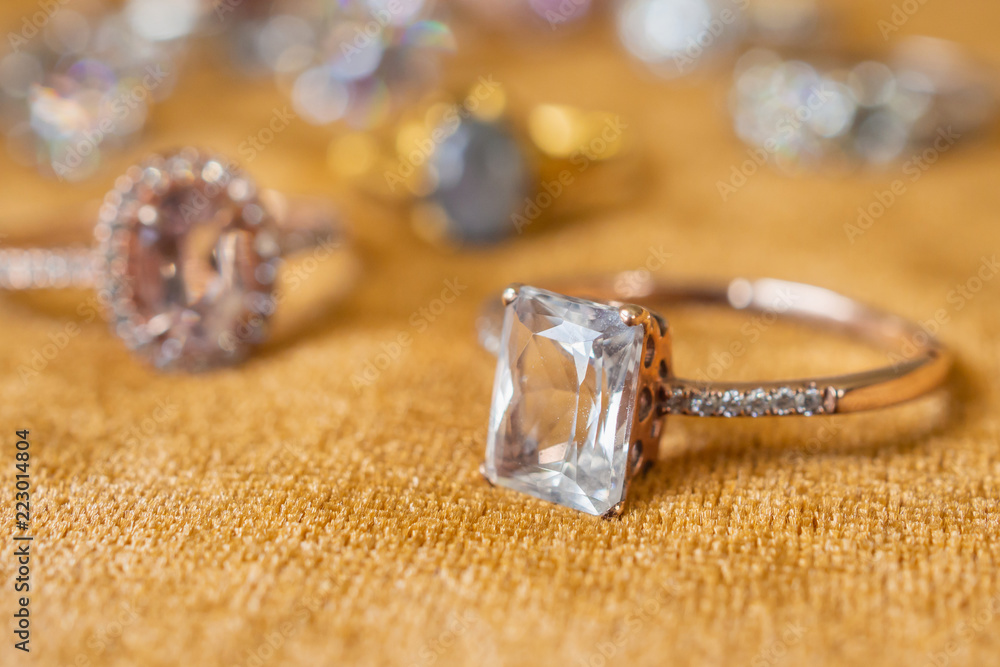 Jewelry diamond rings on golden fabric background close up Jewelry diamond rings on golden fabric background close up