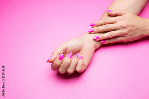 Stylish pink manicure on a pink background