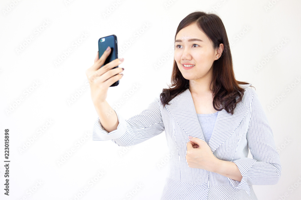 Black hair Asian women take a selfy photo from a smartphone close up on white background. Black hair Asian women take a selfy photo from a smartphone close up on white background.
