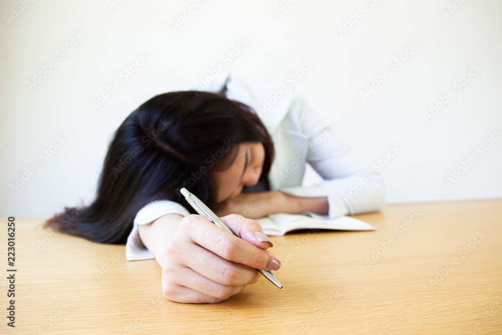 Asian business women napping on the wooden table. Workaholic concept Asian business women napping on the wooden table. Workaholic concept