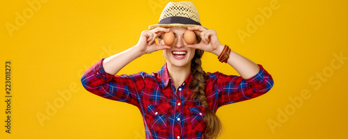 happy woman grower holding eggs in front of face like eyes photo