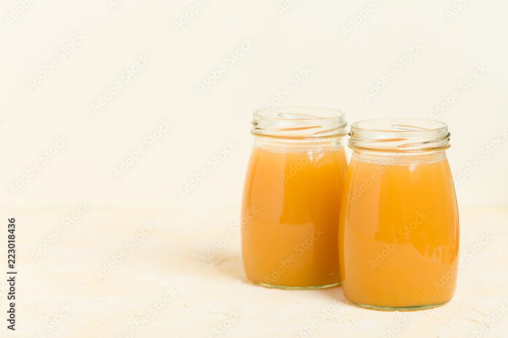 Peach smoothie in glass jars on yellow pastel background. Peach smoothie in glass jars on yellow pastel background.