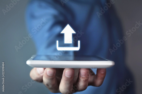 Man holding tablet with web upload icon.