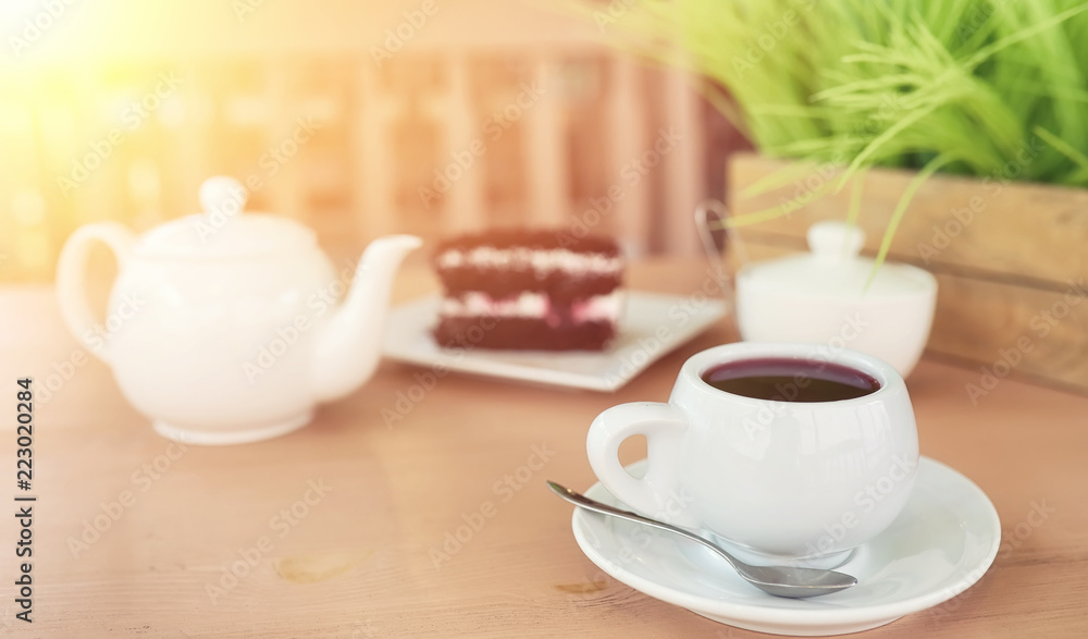 Kettle with a drink and dessert in a street cafe. Tea in the ket Kettle with a drink and dessert in a street cafe. Tea in the ket