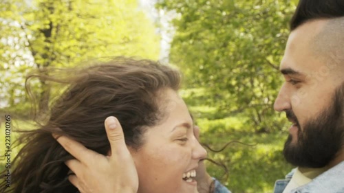 Crop side view of cheerful couple in love looking at each other and laughing on street