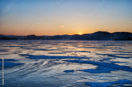 View of beautiful drawings on ice from cracks and bubbles of deep gas on surface of Baikal lake in winter, Russia