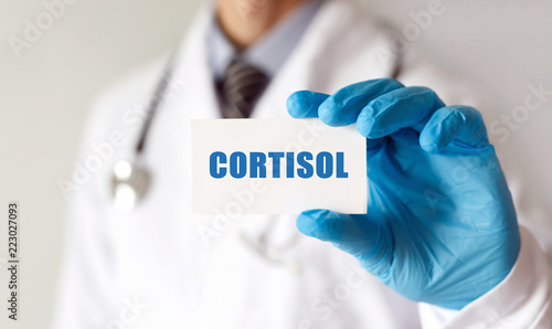 Doctor holding a card with text CORTISOL, Medical concept photo