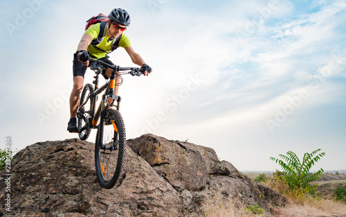Cyclist Riding the Bike on Autumn Rocky Trail at Sunset. Extreme Sport and Enduro Biking Concept.