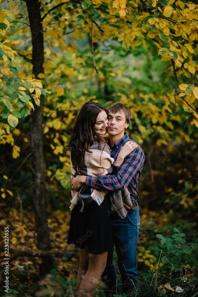 Beautiful woman with a man hugging in the autumn forest. love happiness, youth, family Beautiful woman with a man hugging in the autumn forest. love happiness, youth, family