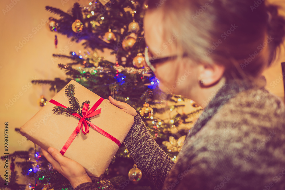 Woman with christmas gift box at the xmas tree. People in happy holidays concept. Woman with christmas gift box at the xmas tree. People in happy holidays concept.