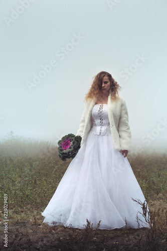 Bride on the field in the fog