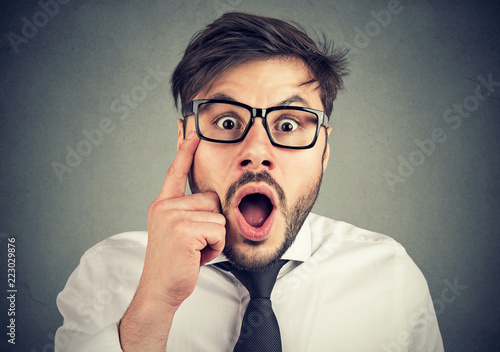 Amazed man in eyeglasses looking at camera