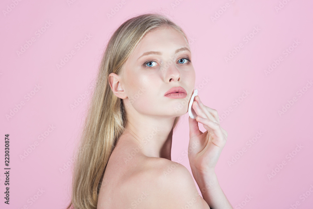 Girl removes makeup. Blonde girl holds cotton pads. Skin care products. Woman with blue eyes. Light makeup. Natural woman beauty. Skin Care. Facial treatment concept. Girl removes makeup. Blonde girl holds cotton pads. Skin care products. Woman with blue eyes. Light makeup. Natural woman beauty. Skin Care. Facial treatment concept.