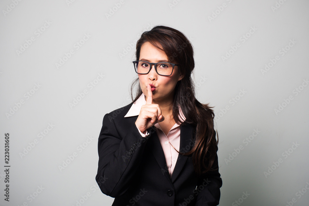 Asian business woman use finger shushing. Sign of quiet. Asian business woman use finger shushing. Sign of quiet.