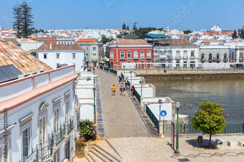 Tourists walk along the bridge in the village of Tavira.