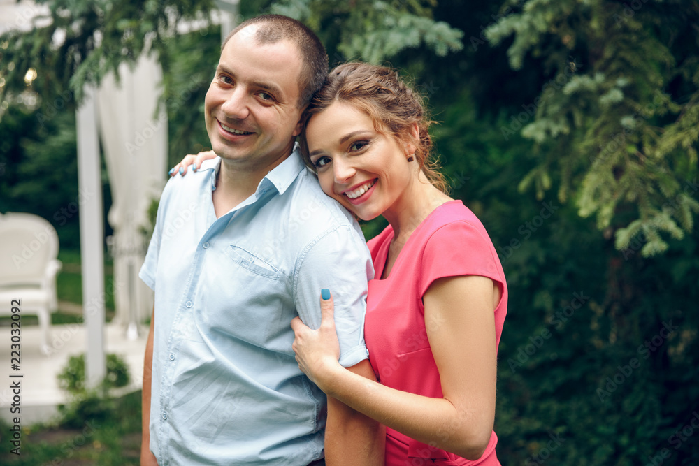 Happy and young pregnant couple in park in summer