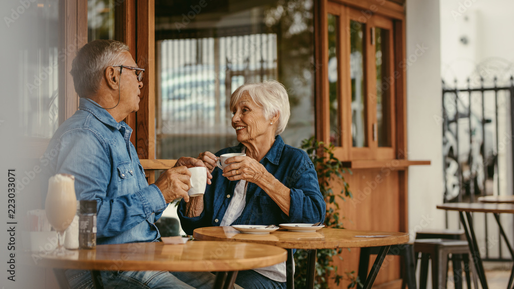 Senior couple talking over a cup of coffee at cafe Senior couple talking over a cup of coffee at cafe