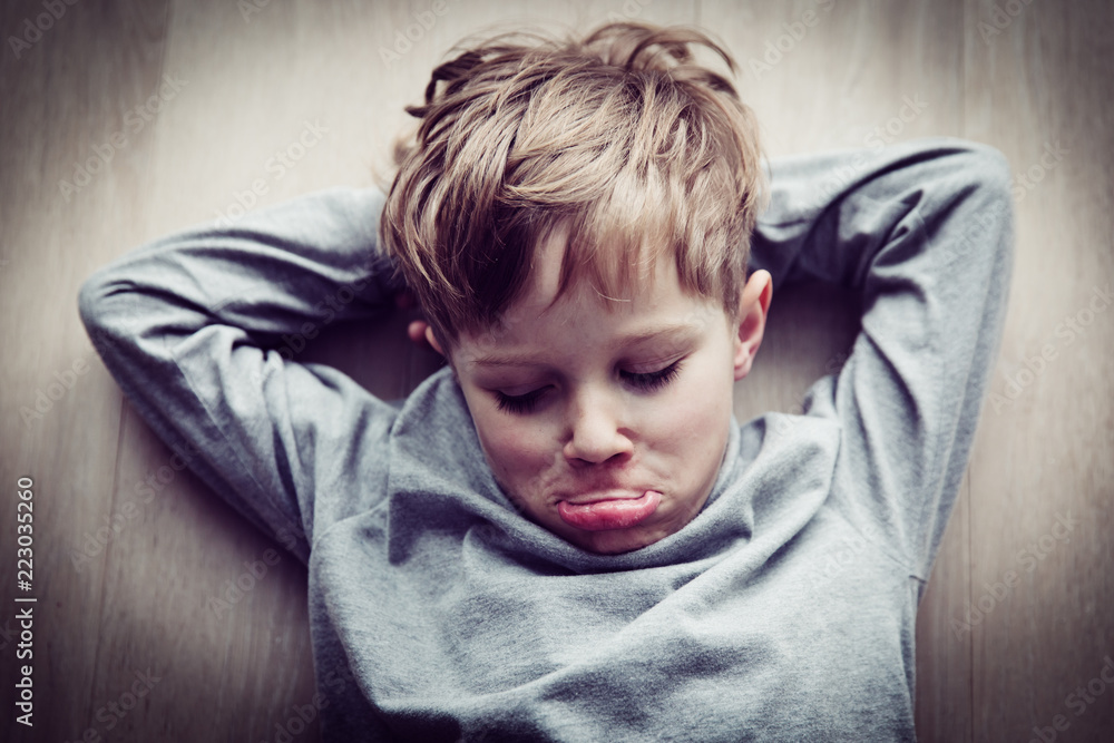 little boy feels annoyed grumpy lying on the floor little boy feels annoyed grumpy lying on the floor