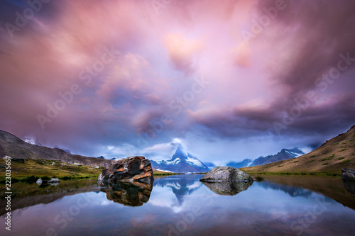 Beautiful sunrise with pink clouds at lake Stellisee with a view of the Matterhorn © Asvolas