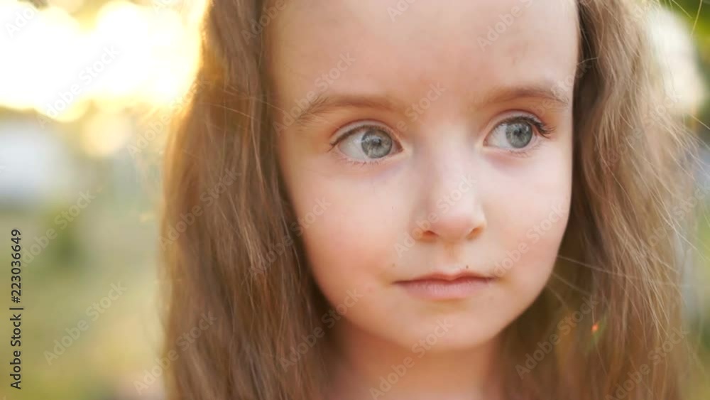 Embarrassed sad gray-eyed, long-haired girl. Little beauty. Close-up, slown motion Embarrassed sad gray-eyed, long-haired girl. Little beauty. Close-up, slown motion