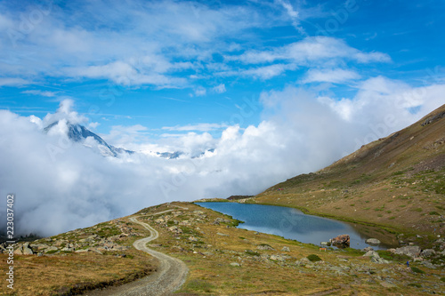 Lake Stellisee with lots of clouds and fog rolling in and a view of the Matterhorn