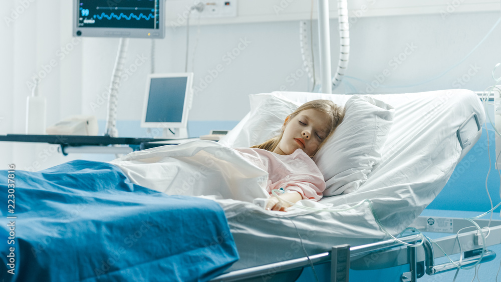Cute Little Sick Girl Sleeps on a Bed in the Children's Hospital. Modern Pediatric Ward with Top Quality Health Care. Cute Little Sick Girl Sleeps on a Bed in the Children's Hospital. Modern Pediatric Ward with Top Quality Health Care.