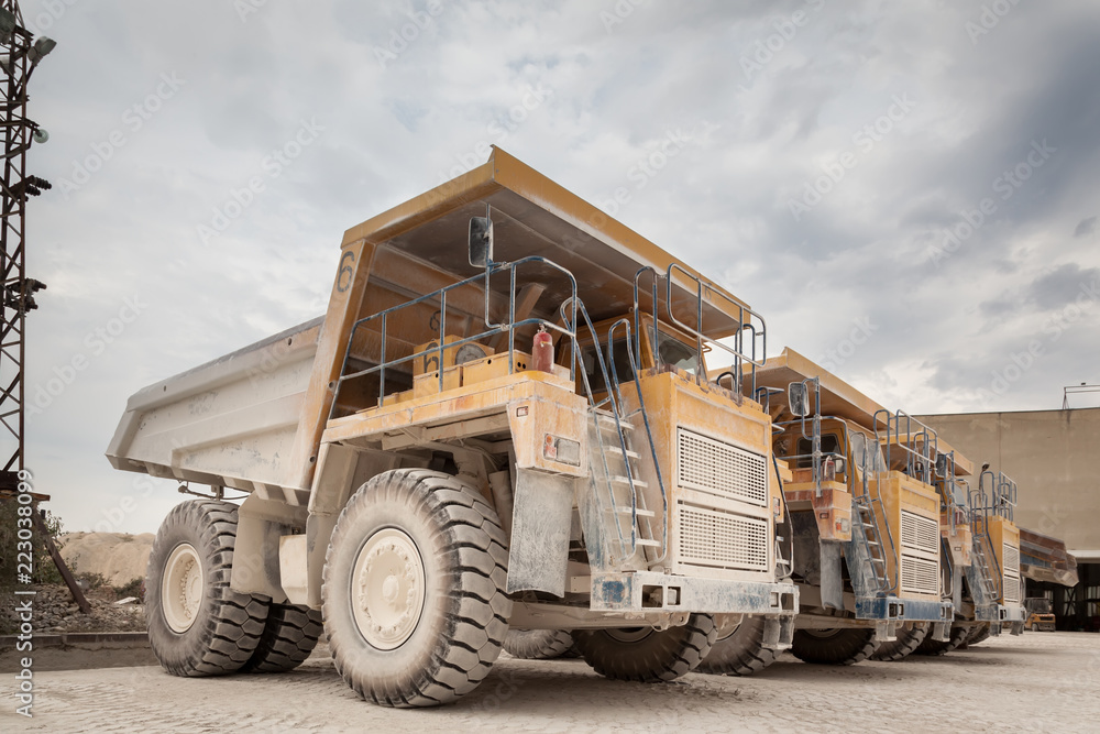 Big yellow dump trucks in the stone quarry. Mining trucks, mining machinery for transport