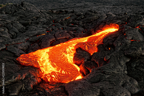 Hot magma escapes from an earth crevice as part of an active lava flow, the glowing lava slowly cools and freezes - Location: Hawaii, Big Island, volcano "Kilauea"