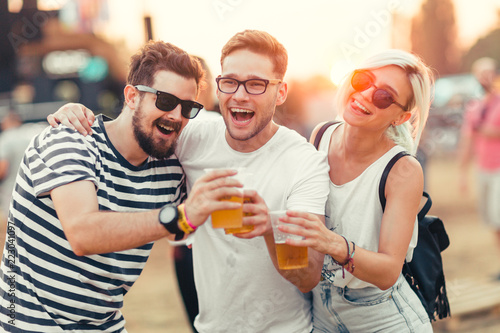 Friends drinking beer and having fun at music festival  photo