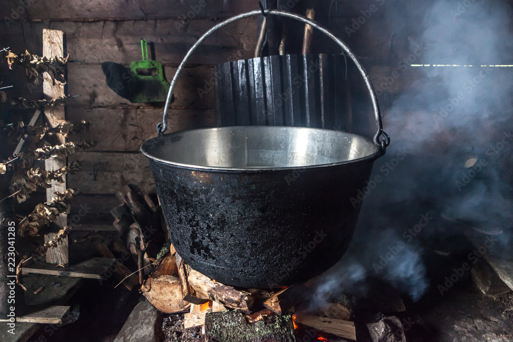 Steaming old-fashion pot with soup over fire Steaming old-fashion pot with soup over fire
