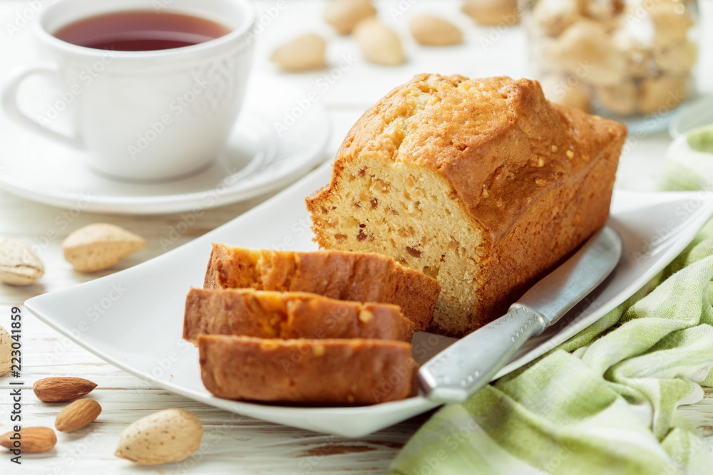 Sliced pound cake with almonds on the cutting Board. Homemade cake with nuts and honey. Delicacy snack for tea Sliced pound cake with almonds on the cutting Board. Homemade cake with nuts and honey. Delicacy snack for tea