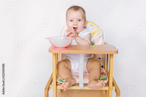 Baby girl with spoon on white background