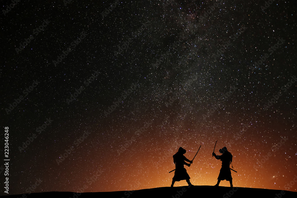 Silhouette of two samurais against the starry sky. Deadly warriors with swords