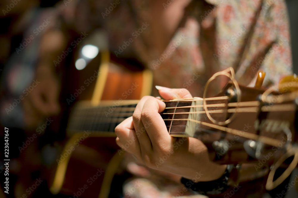 Fototapeta premium Practicing in playing guitar. Handsome young men playing guitar